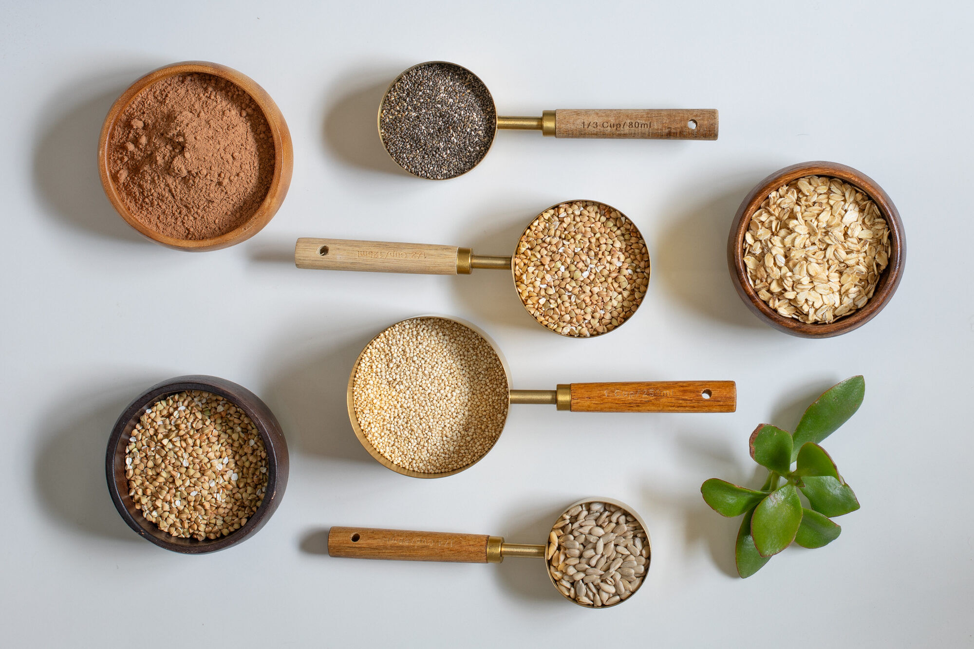 Quinoa, chia, cacao, and almonds arranged on a stone surface.
