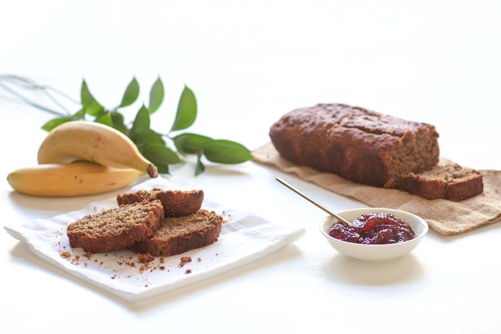 A sliced banana loaf cooling on a kitchen counter.